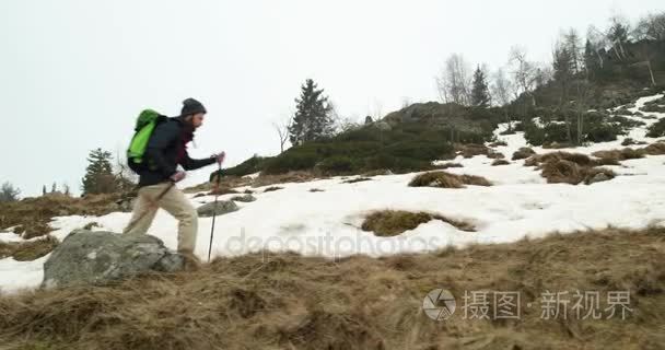 在多雪的线索路径上行走的背包徒步旅行者的男人。后侧。真正的背包客人成年后徒步旅行或在秋天或冬天在野生山户外徒步性质，坏雾 wea