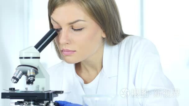 女化学家，科学研究者在实验室中使用显微镜