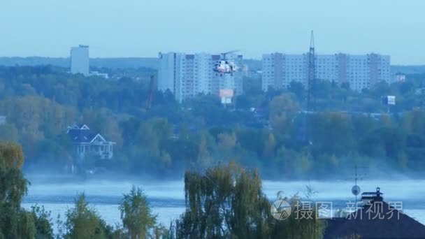 这架直升机收集水在河里去灭火。救援和消防队员将大火扑灭。直升机在空中盘旋。火在莫斯科举行。军用直升机