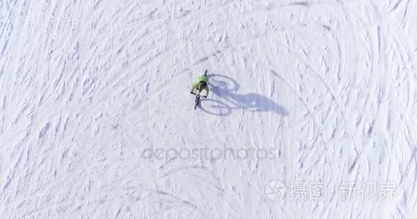 骑自行车的人的结核分枝杆菌的 e 自行车冬季下雪路上骑车人在空中的开销。在户外在冬天的雪地上骑自行车。4 k 顶视图飞行视