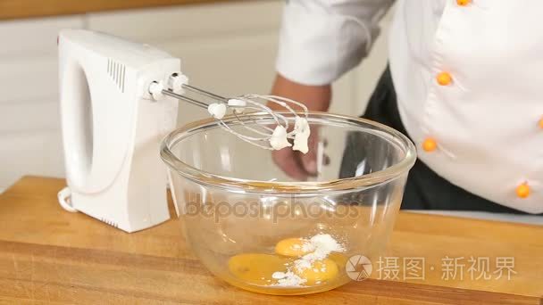 用搅拌器搅拌鸡蛋 黄油和糖在一个玻璃碗