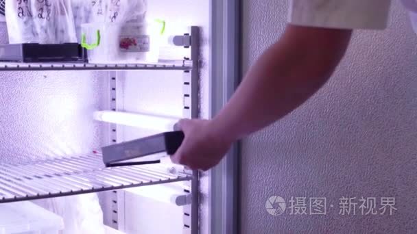 实验室助理将试验样品放在冰箱视频
