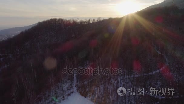 空中无人机的飞行在白雪皑皑的丛林树林在日落和行走的人。在山自然户外的冬天雪。阳光 light.travel 阿尔卑斯山探险。4 