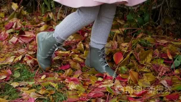 女婴躺在秋叶粉红色的大衣视频