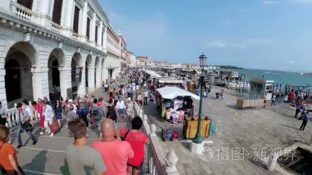 一群人沿着意大利威尼斯的堤岸漫步