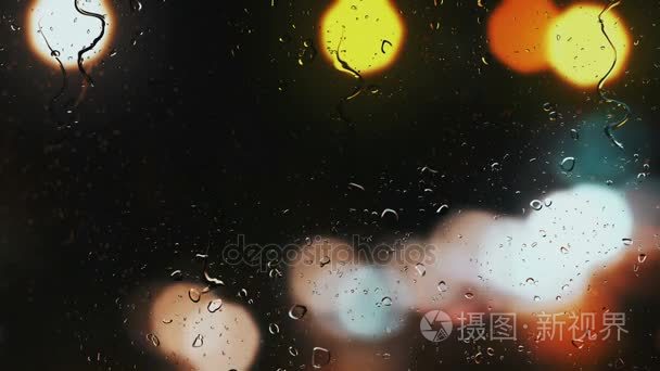 汽车车窗上的雨滴  街道交通灯背景模糊