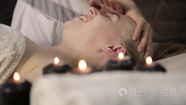 美容师为美丽的女性在水疗沙龙做脸部按摩视频