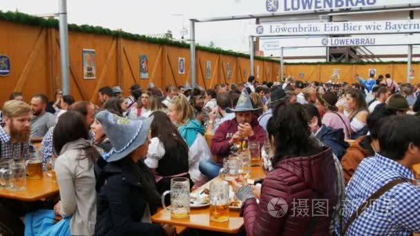 2017年9月17日-慕尼黑  德国: 年轻人坐并且庆祝在 beergarten 在世界范围的巴法力亚节日啤酒节。人们喝大玻璃杯