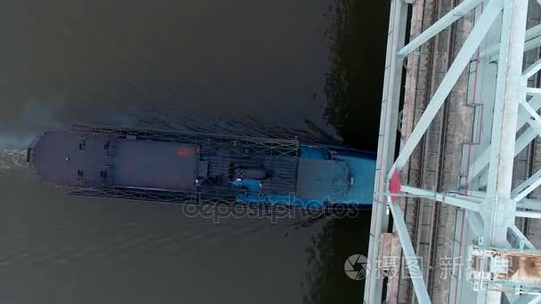 一艘货船在桥下移动的高角度视频