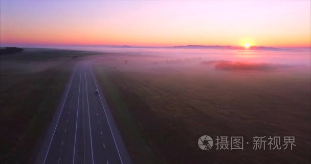 有汽车的道路鸟瞰图  日出时布满雾气的田野。俄罗斯