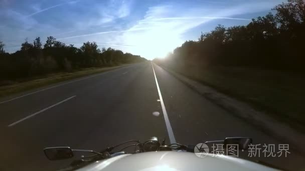 骑车骑摩托车在公路上迎接太阳视频