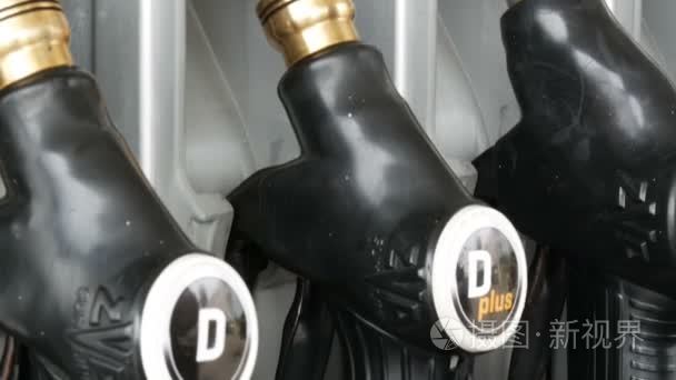 不同的老加油手枪为倾吐的汽油垂悬在列在加油站。汽油或加油站气体燃料泵喷嘴