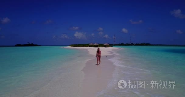 v13785一个美丽的年轻女孩在比基尼泳装日光浴和漫步在白色沙滩上的水