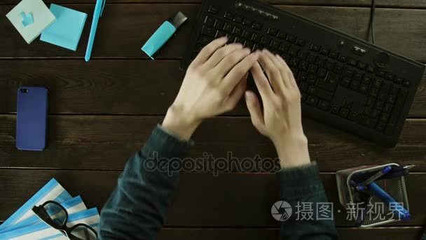 一个男人在电脑上用手和键盘打字