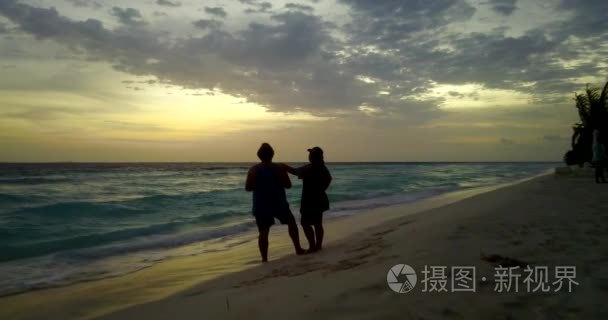 v13987 两2日落年轻人浪漫情侣日光浴与无人驾驶飞机鸟瞰在沙滩上的白色沙滩和美丽的岛屿背景视频