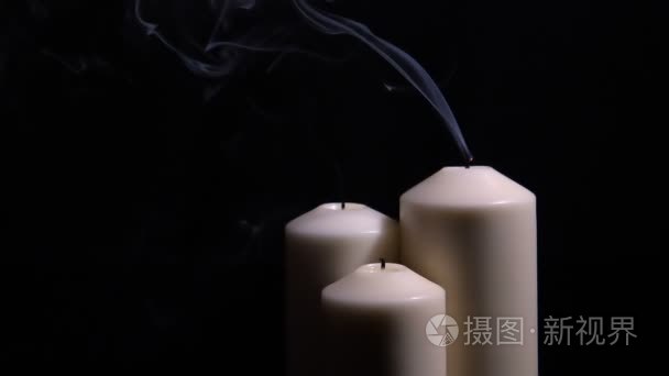 三熄灭的蜡烛与烟雾在黑色背景视频