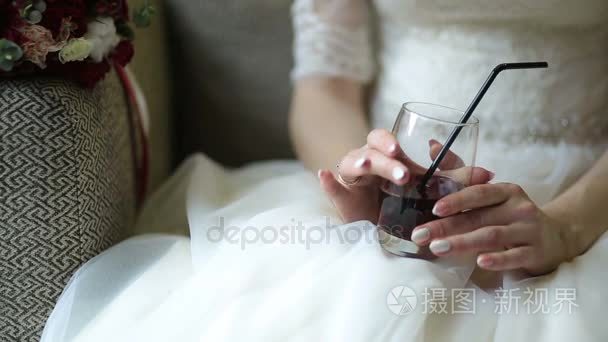 近距离观看的新娘手指甲拿着玻璃杯与红色饮料, 而坐在咖啡馆