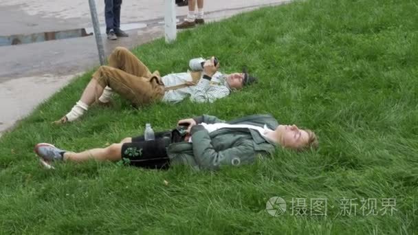 醉酒的人躺在巴伐利亚雕像附近的草地上, 在慕尼黑啤酒节。巴伐利亚, 德国