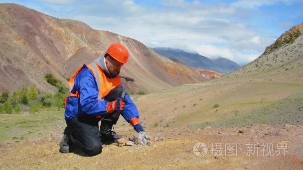 地质学家用锤子敲打岩石视频