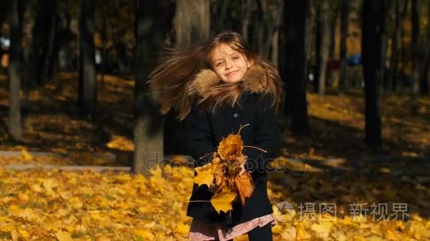 快乐的小女孩抛出叶子