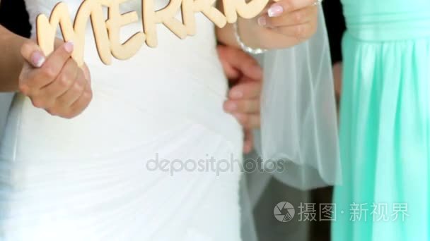 幸福的新婚夫妇手持木质标语牌刚刚结婚。婚礼日