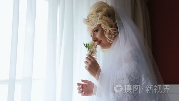 金发碧眼的新娘闻胸花站在窗前视频