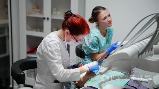 牙医和护士修复病人的牙齿。用 bormashenko 钻牙, 消除蛀牙和封口