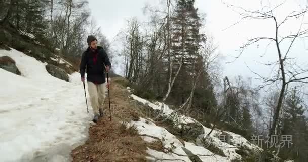 徒步旅行者背着背包走在雪地小路上。跟着前面真正的背包人成人徒步旅行或在秋季或冬季野外远足自然, 恶劣的大雾天气. 4 k 视频