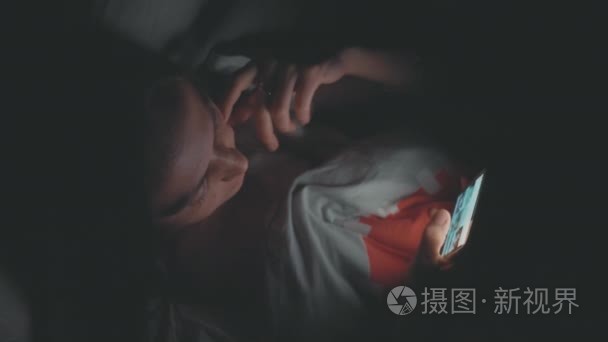 晚上在床上用手机的年轻女人视频