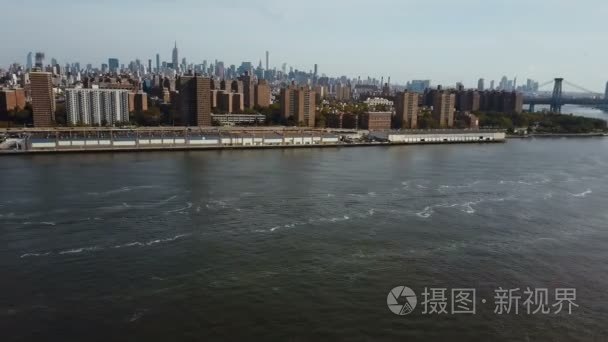 美国纽约曼哈顿大桥和区的鸟瞰图。无人机在东河岸边转弯
