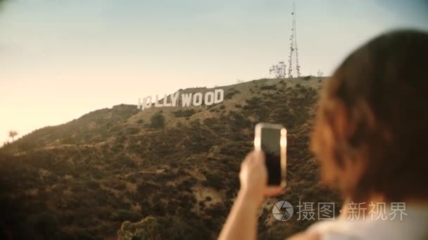 游客在好莱坞标志中拍照日落