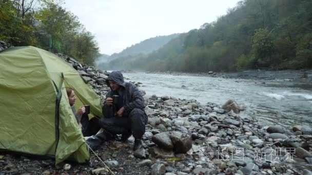 4k. 从一条山上的观光帐篷看。那个女孩把茶倒进热水瓶里, 看着那条山