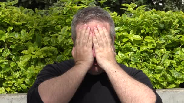 一个戴着内疚表情的长胡子的年轻人的肖像.隔离在灰色背景上