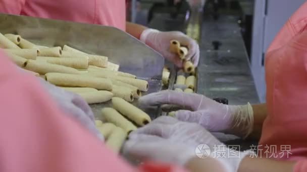 工人们把食物饼干装进容器  包里。杂货零售商和配送