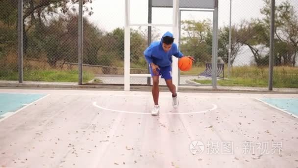 年轻的非洲裔美国人在外面练习篮球。Slowmotion 射击