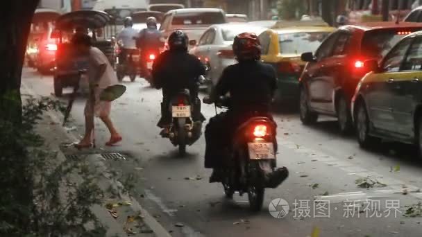 曼谷  泰国-2012年10月24日。曼谷街头的交通。移动汽车  摩托车  tuktuk。强风吹