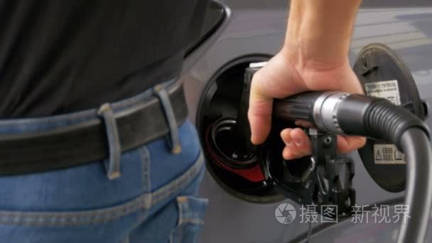 用柴油加油的人。男子手使用汽油泵填补他的汽车与燃料