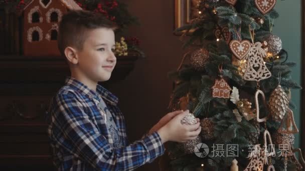 一个小男孩装饰一棵圣诞树