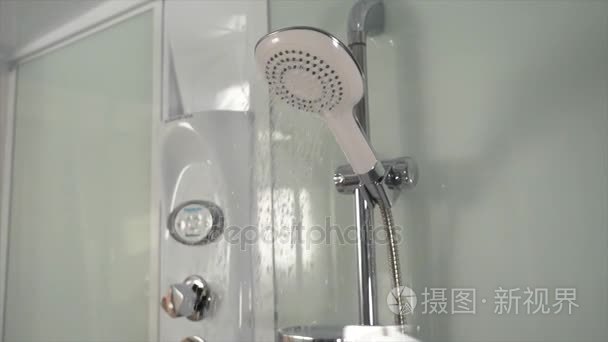 淋浴水龙头的自来水。淋浴喷头在浴室与水滴流动。现代淋浴带水