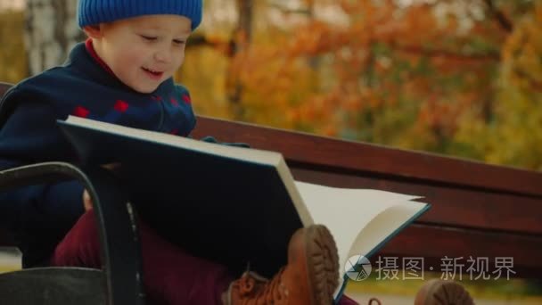小男孩在秋天公园看大家庭相册视频