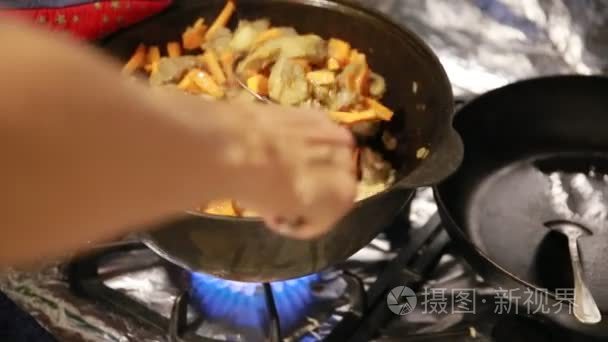 开始烹调饭  上肢搅动肉与红萝卜在 cast-iron 水壶