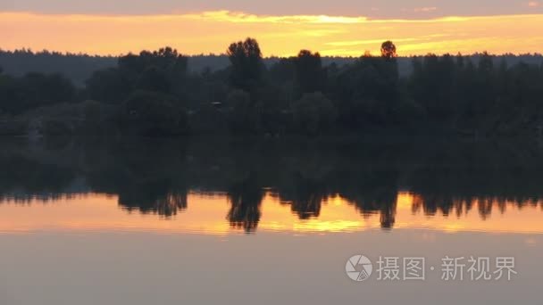 一个森林湖与黑水  波光粼粼的表面  木质海岸在日落