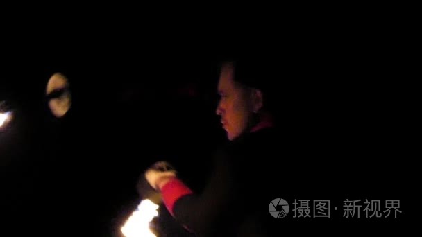 马戏团的人把两个点亮的 Flambeaux 转过来他们在斯洛伐克的夜晚看起来很神奇