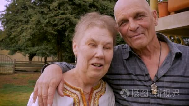 快乐的老年夫妇在70s 微笑, 看着相机