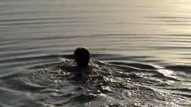 一个悠闲的女人在日落湖边游泳视频