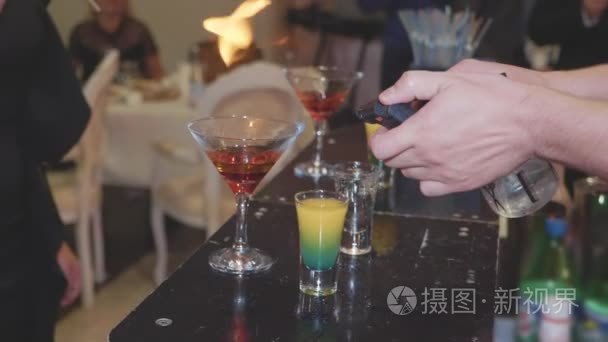 酒吧招待员准备一杯鸡尾酒，并放火烧了它