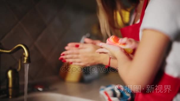 妈妈帮女儿洗完饭后在厨房洗手视频