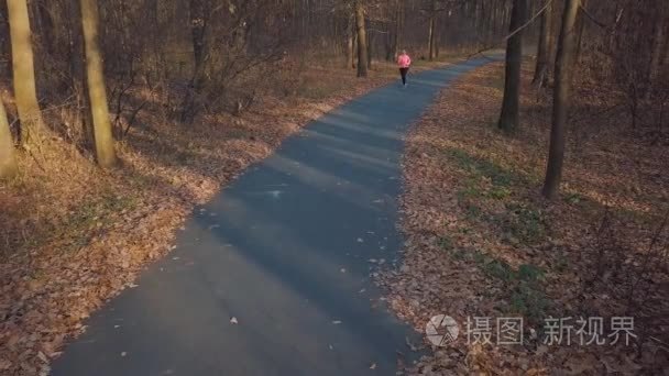 在夕阳下奔跑的女人的鸟瞰图