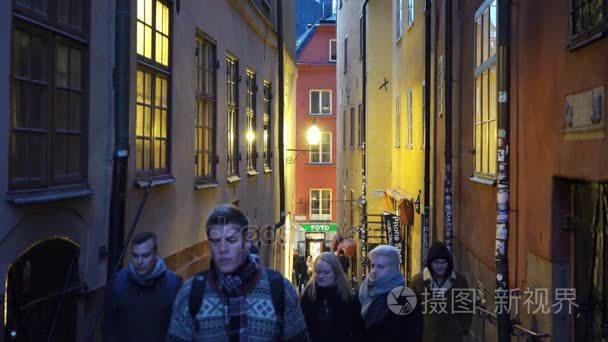 许多人在斯德哥尔摩的节日街道上。圣诞假日装饰品和灯饰在狭窄的街道格姆拉斯坦的老镇斯坦