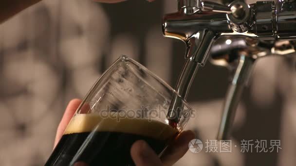 酒保把一杯黑啤酒倒在玻璃特写视频